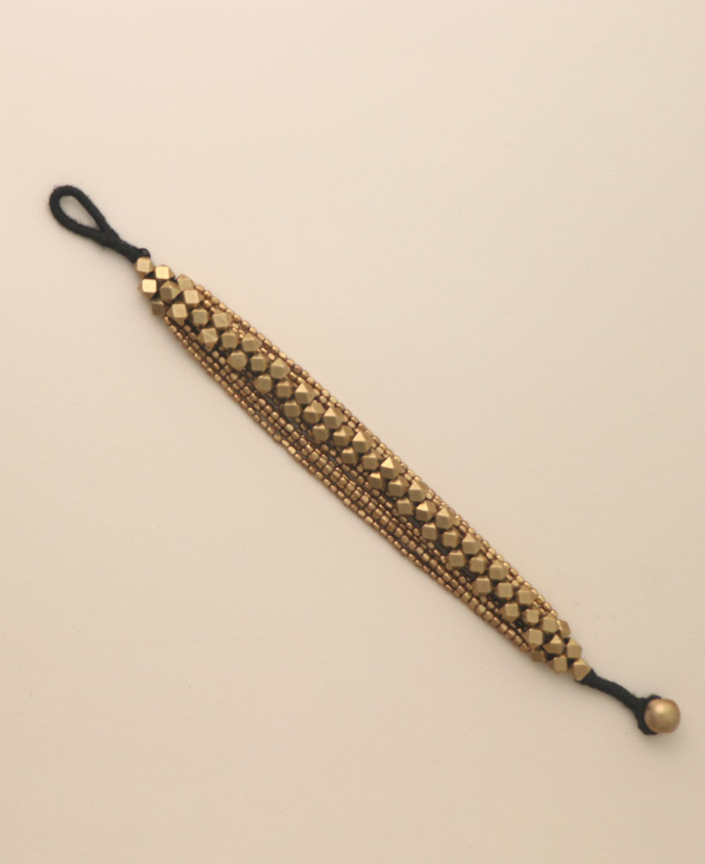 Close-up of intricate brass bead bracelet with button closure