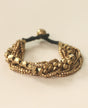 Multi-strand brass beaded bracelet on beige background