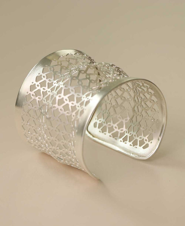 Handcrafted silver-tone cuff bracelet with intricate design.