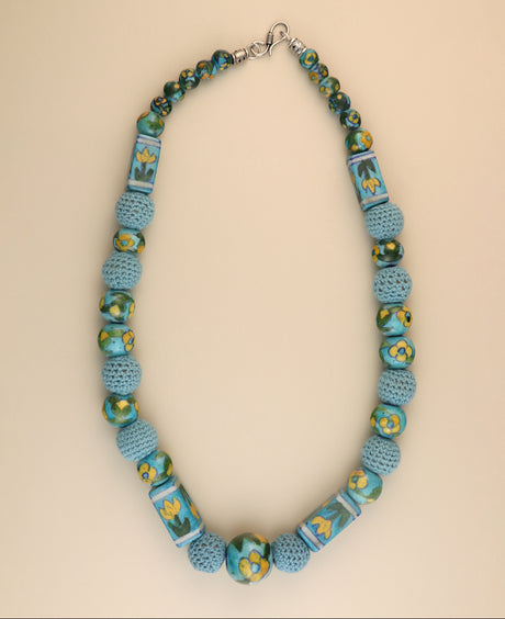 Floral ceramic bead necklace with crochet accents.