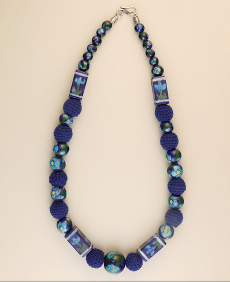 Blue floral ceramic bead necklace with crochet accents.