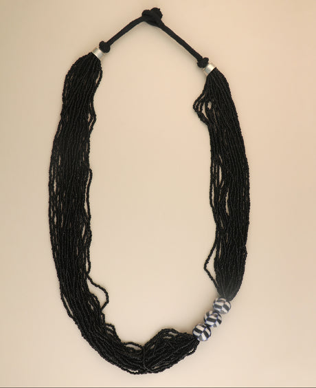 Multi-strand black glass bead necklace with ceramic accents.