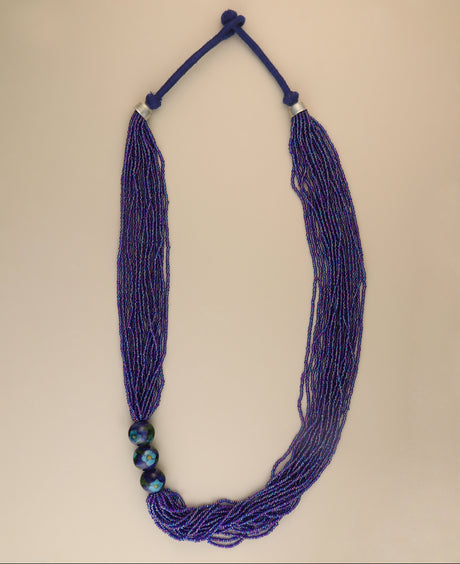 Multi-strand blue glass bead necklace with ceramic accents.