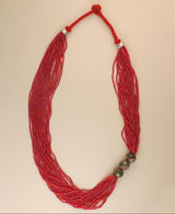 Multi-strand red glass bead necklace with ceramic accents.