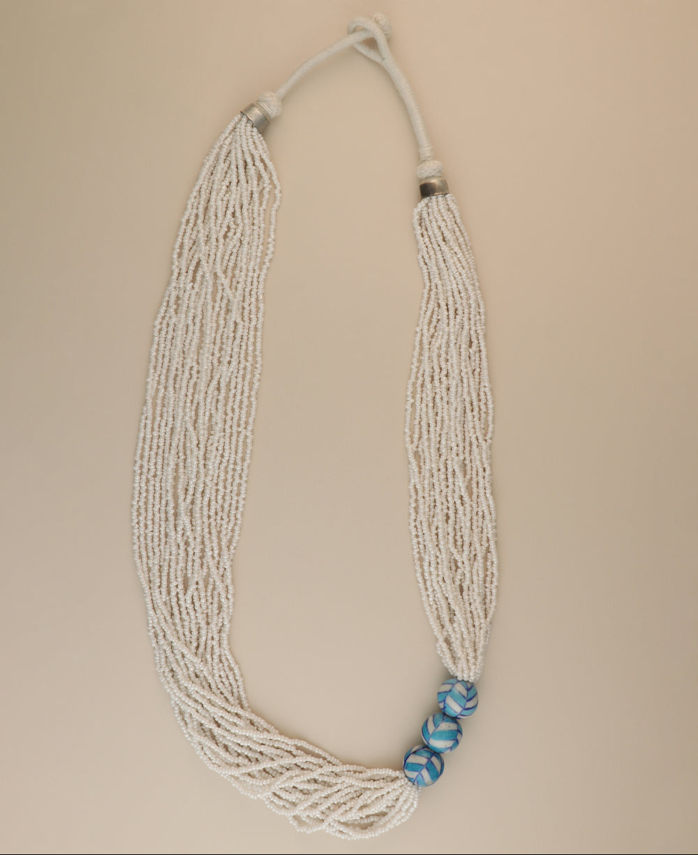 Multi-strand white glass bead necklace with ceramic accents.