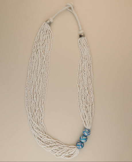 Multi-strand white glass bead necklace with ceramic accents.