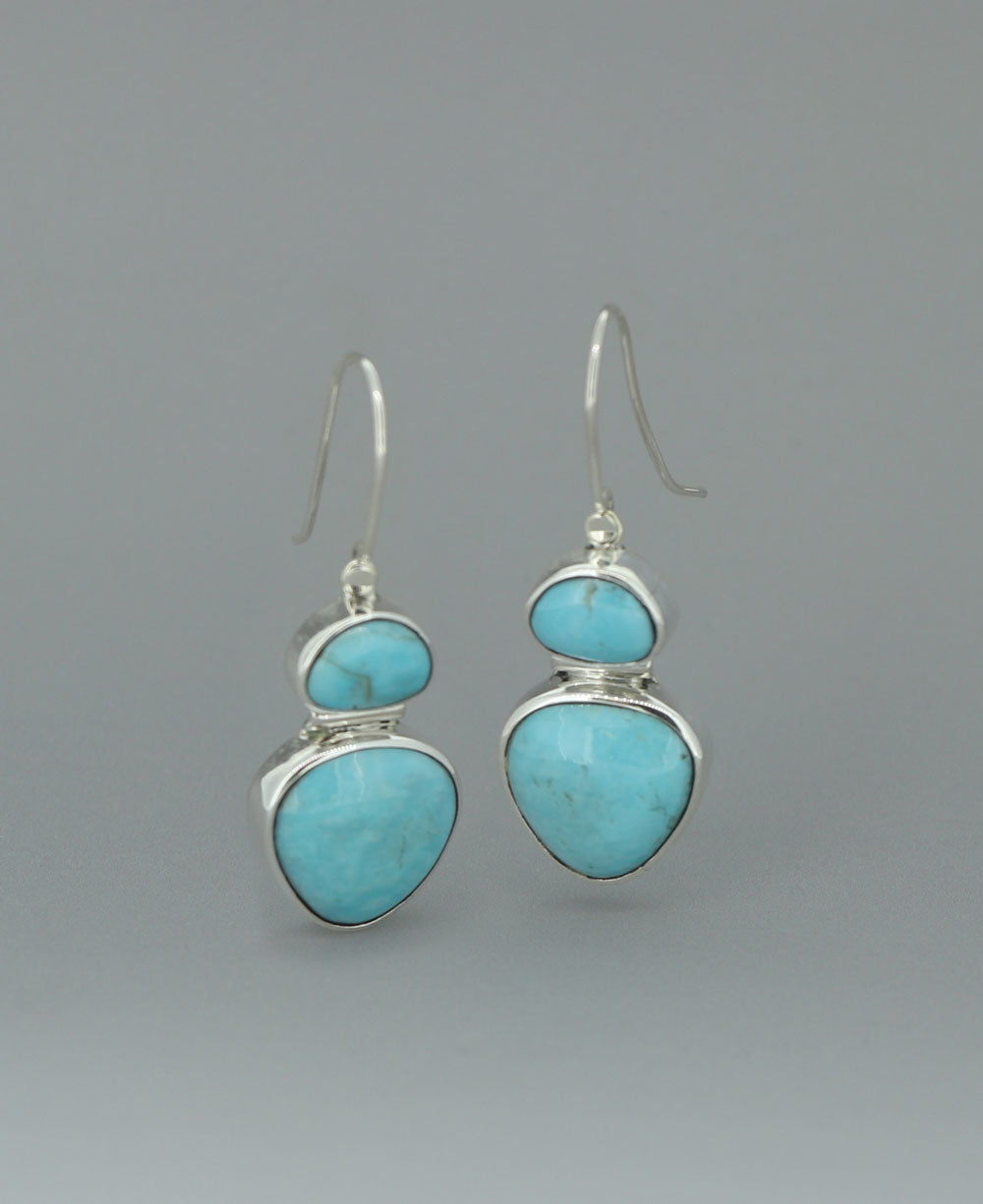 Full view of the sterling silver Genuine Turquoise dangling earrings against a light background, emphasizing the vibrant Kingman turquoise