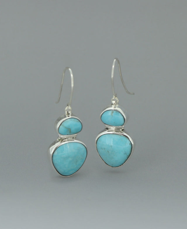 Full view of the sterling silver Genuine Turquoise dangling earrings against a light background, emphasizing the vibrant Kingman turquoise