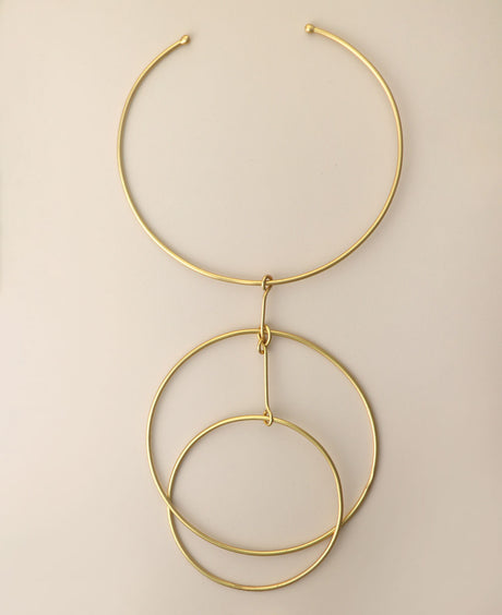 Minimalist brass hoop choker necklace on beige background